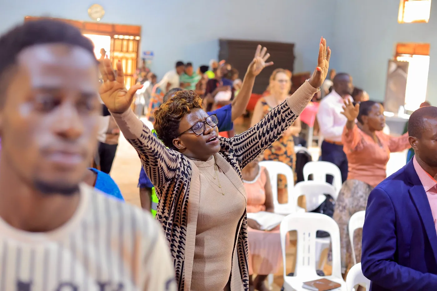 A woman standing in worship with her arms lifted