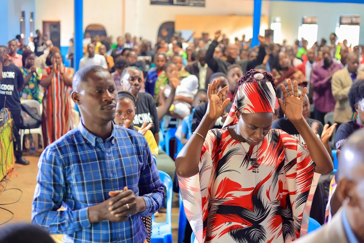 A man and a woman praying together in the congregation