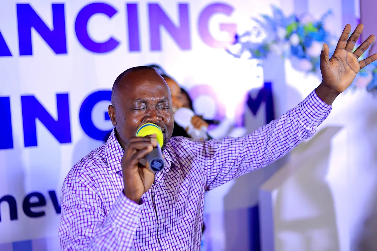 A man teaching from the platform with a microphone
