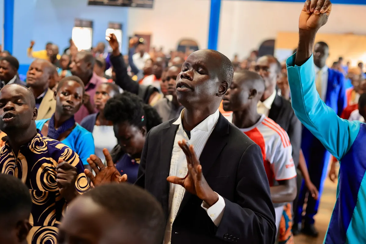 A man clapping during a song in the gathering