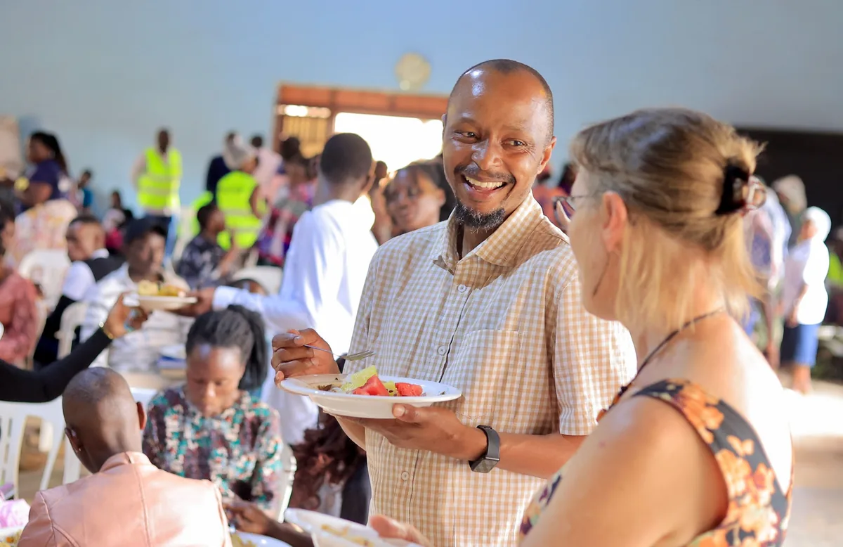 A man smiling as he receives a plate of food