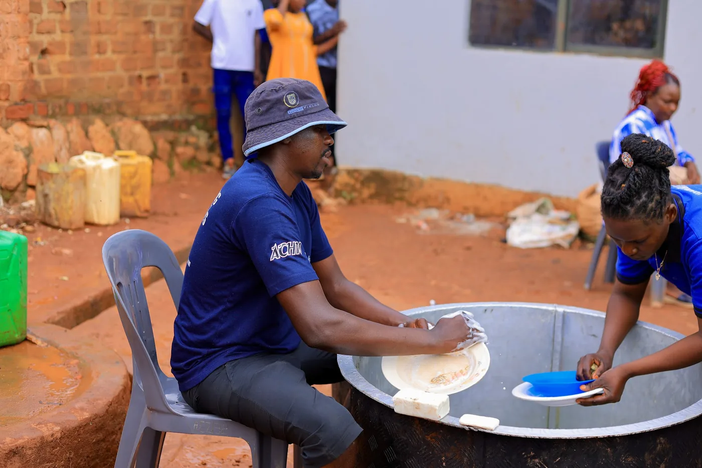 Members washing plates after a shared meal