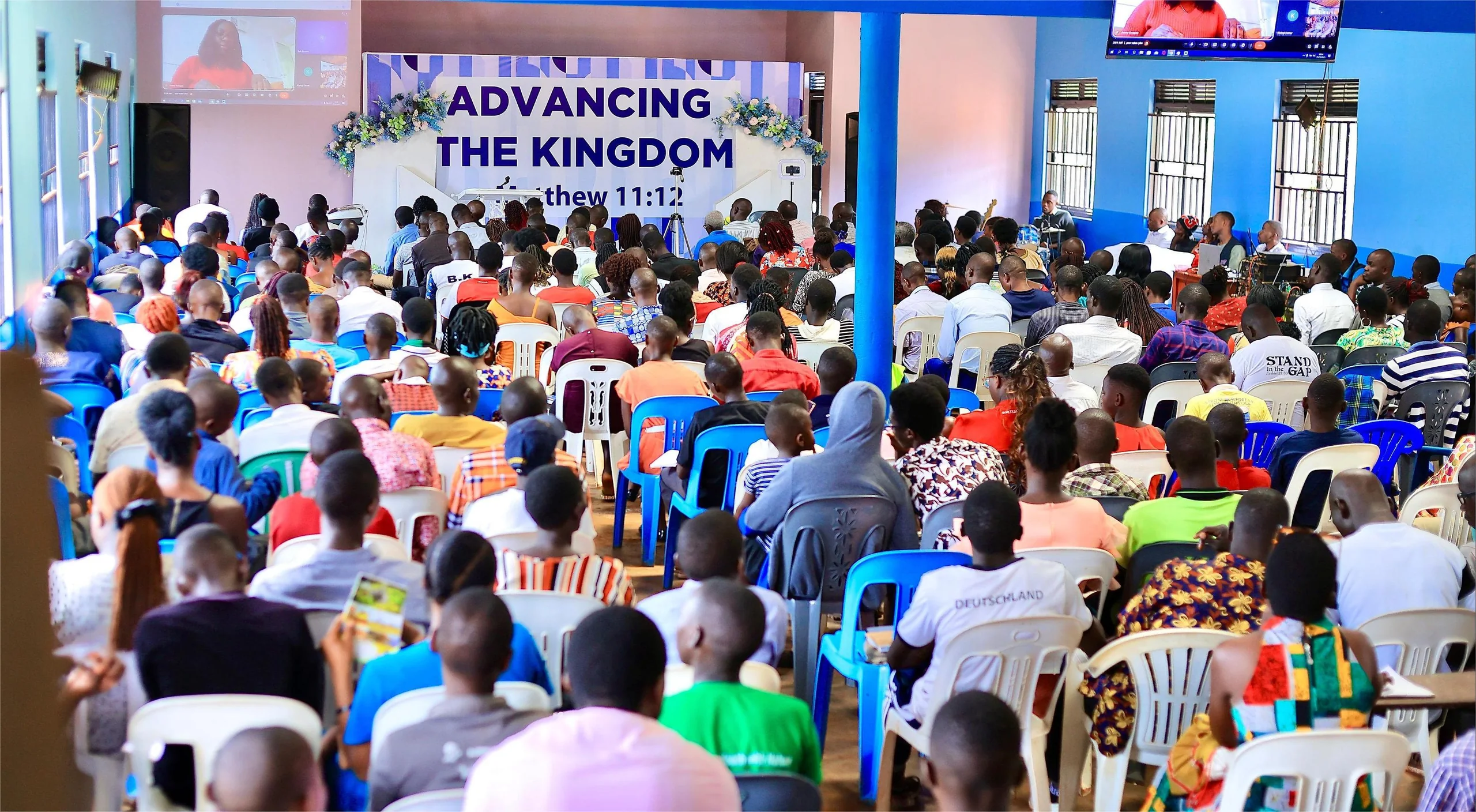 The congregation gathered for worship beneath the Advancing the Kingdom banner