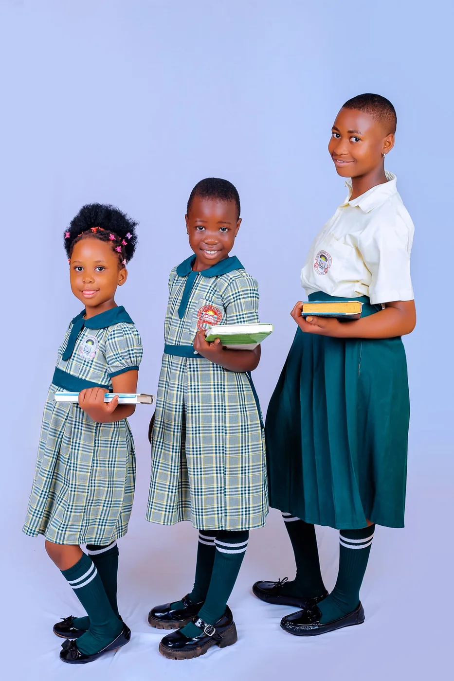 Three pupils in their Right Care uniforms, holding their books
