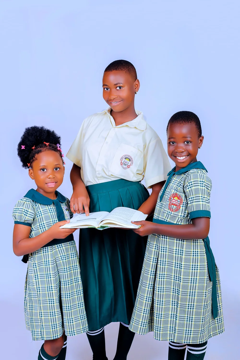 Three pupils reading an open book together