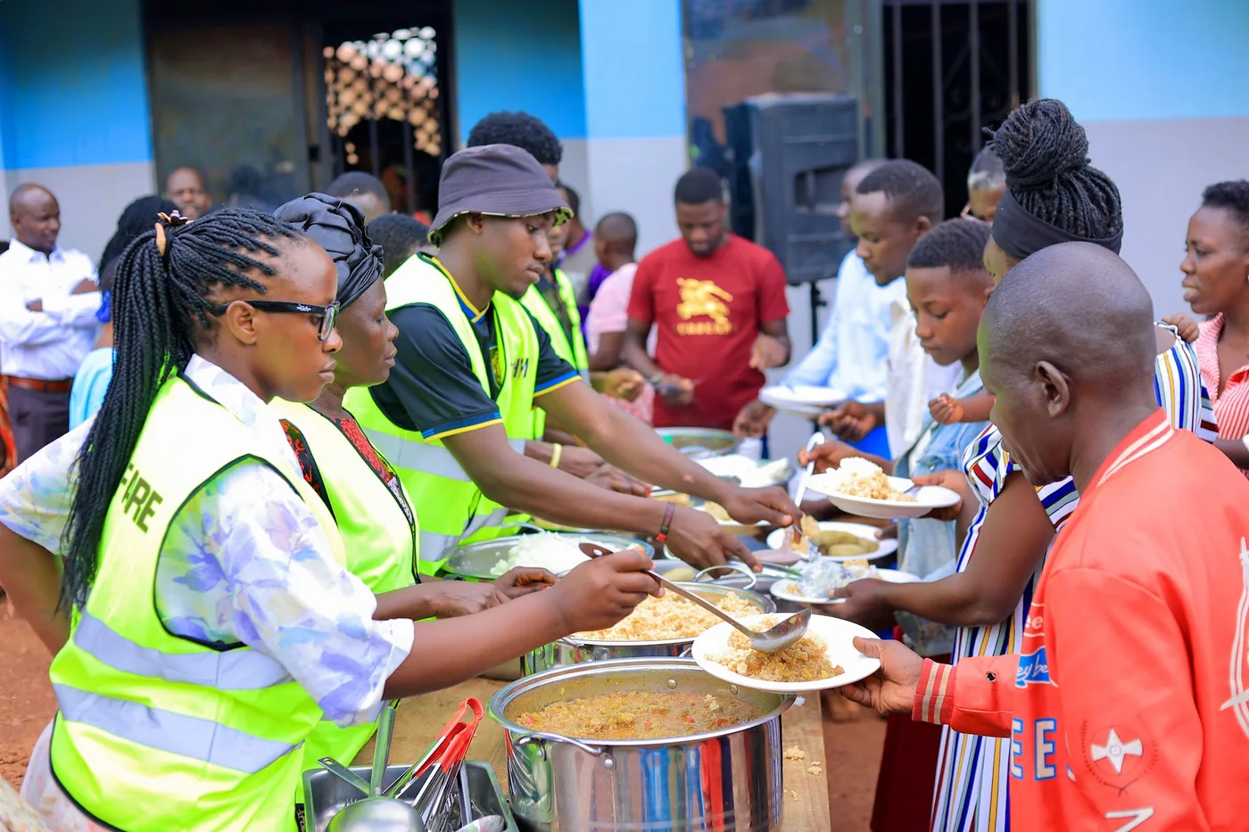 Volunteers serving meals to the gathered community