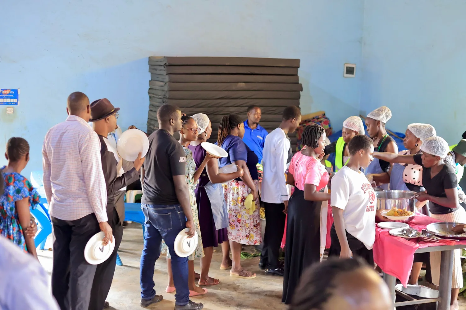 Volunteers serving food to the gathered community